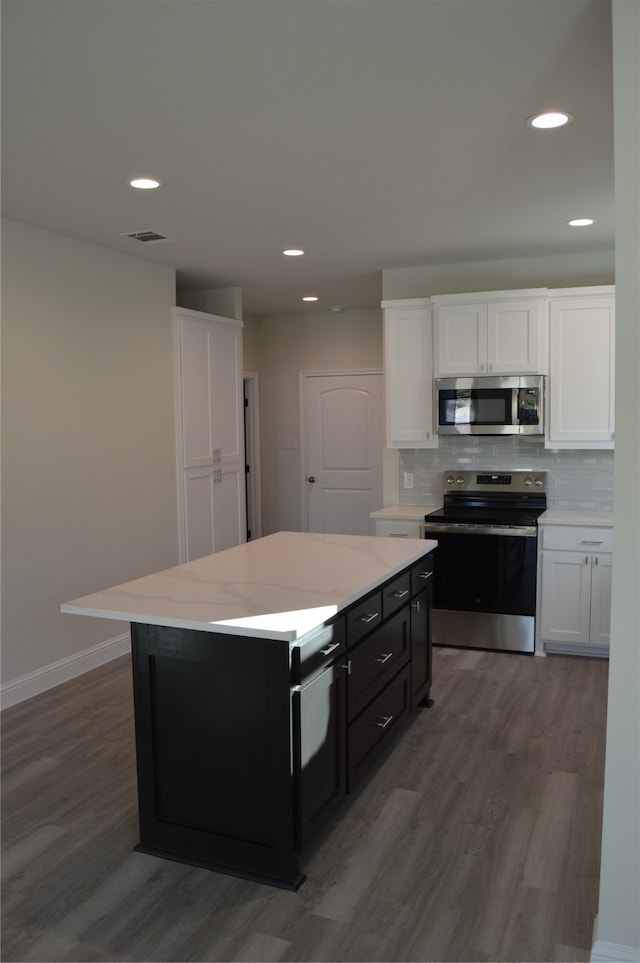 kitchen featuring stainless steel appliances, white cabinetry, and hardwood / wood-style flooring