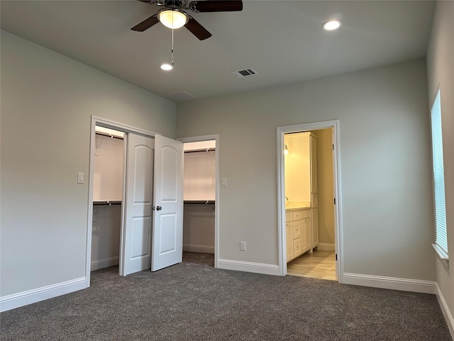 unfurnished bedroom featuring visible vents, carpet, ensuite bath, and baseboards
