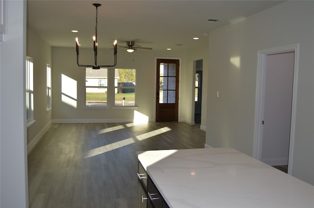 unfurnished dining area with dark hardwood / wood-style flooring and a chandelier