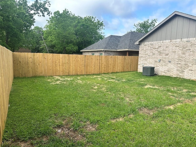 view of yard with central AC and a fenced backyard