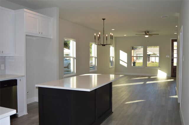 kitchen with dishwasher, a center island, white cabinets, dark hardwood / wood-style floors, and decorative light fixtures