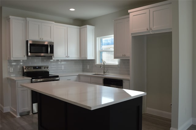 kitchen with white cabinets, a kitchen island, dark hardwood / wood-style flooring, and stainless steel appliances