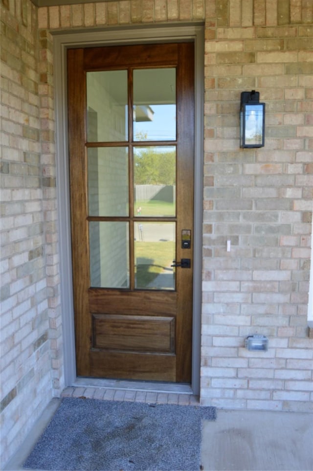 doorway to property with brick siding