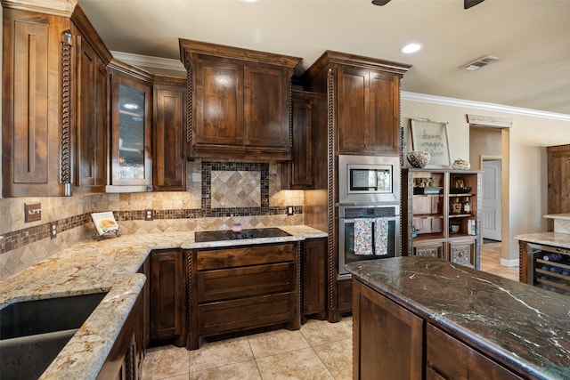 kitchen featuring tasteful backsplash, dark stone countertops, dark brown cabinetry, ornamental molding, and stainless steel appliances