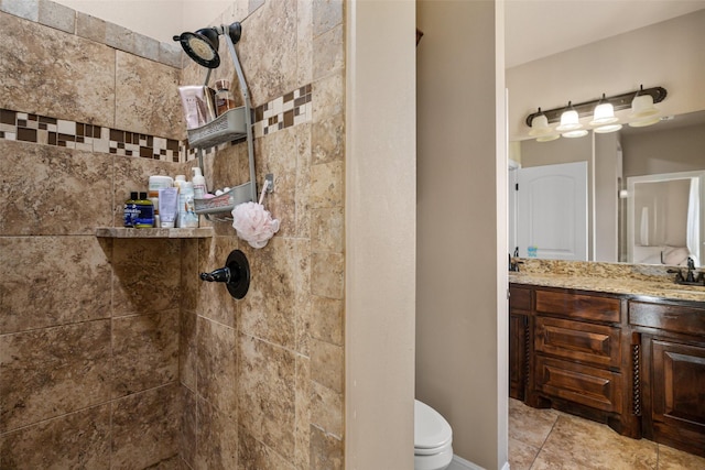 bathroom with vanity, toilet, and a tile shower