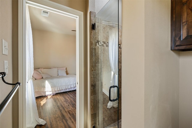 bathroom featuring hardwood / wood-style flooring and walk in shower