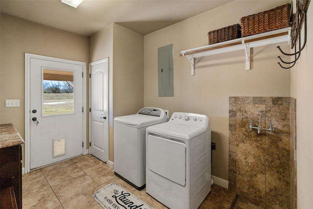 laundry room featuring electric panel, light tile patterned floors, and washer and dryer