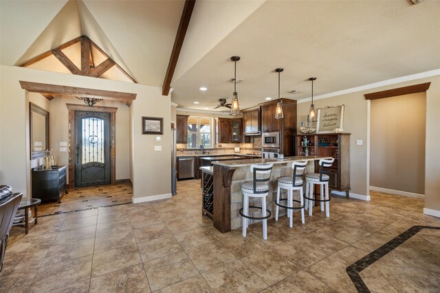 kitchen with decorative light fixtures, a breakfast bar area, a center island, and stainless steel appliances