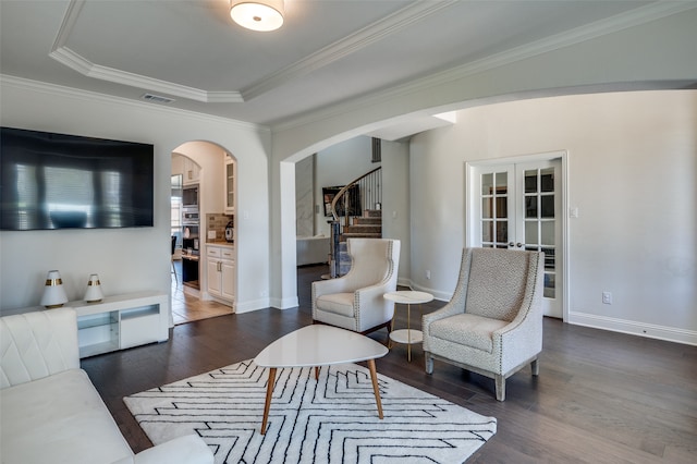 living room featuring french doors, dark hardwood / wood-style flooring, a tray ceiling, and ornamental molding