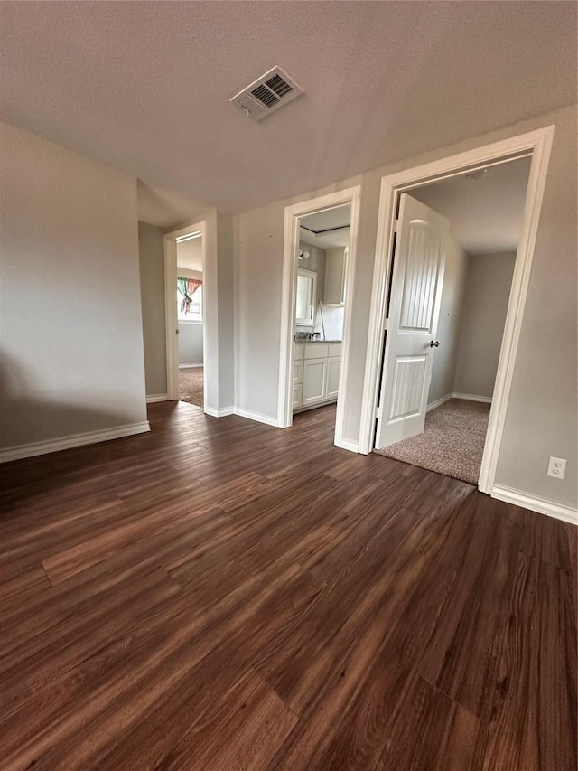 interior space featuring a textured ceiling and dark wood-type flooring