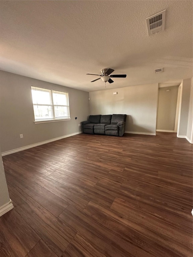 unfurnished living room with a textured ceiling, ceiling fan, and dark wood-type flooring