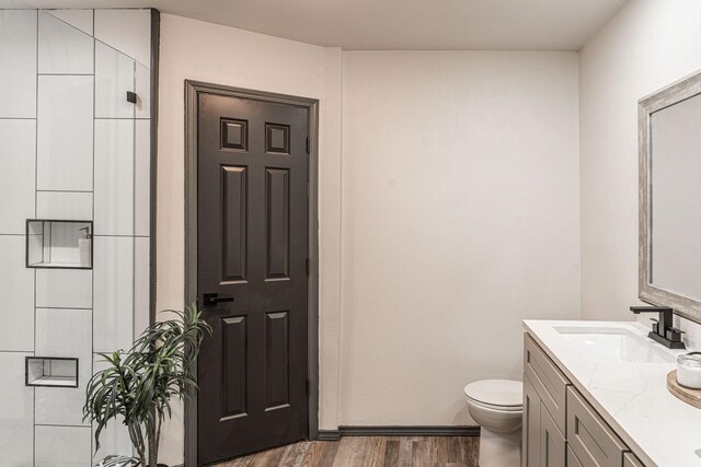 bathroom with vanity, toilet, and wood-type flooring