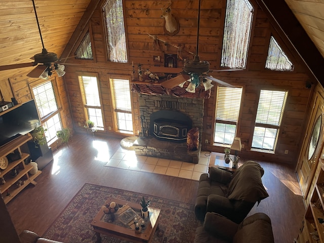 living room featuring dark hardwood / wood-style floors, high vaulted ceiling, a wealth of natural light, and wood walls