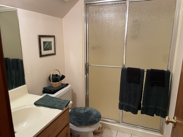 bathroom featuring tile patterned flooring, vanity, toilet, and a shower with shower door