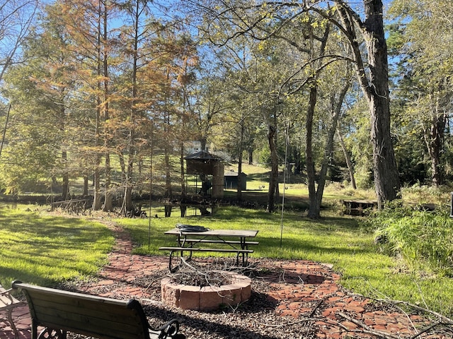 surrounding community with a yard and a fire pit