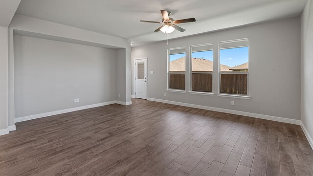 empty room with ceiling fan and dark wood-type flooring