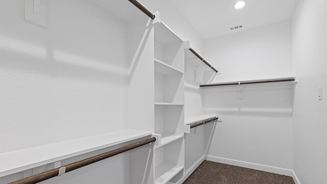 spacious closet featuring dark colored carpet