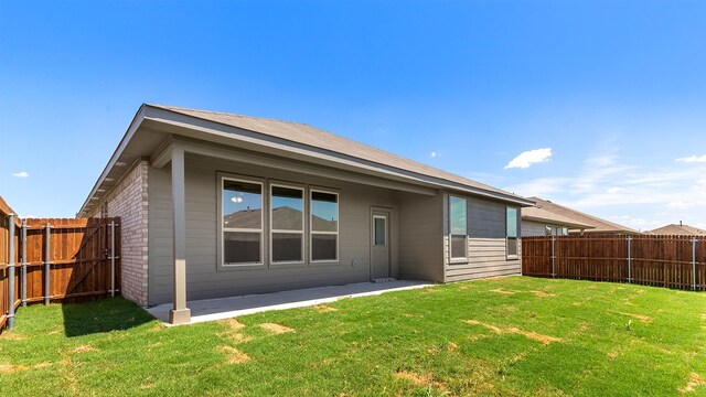 rear view of property with a yard