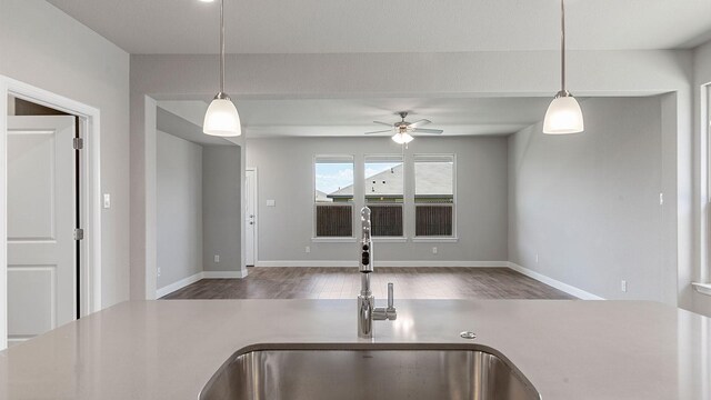 kitchen with hardwood / wood-style floors, ceiling fan, hanging light fixtures, and sink