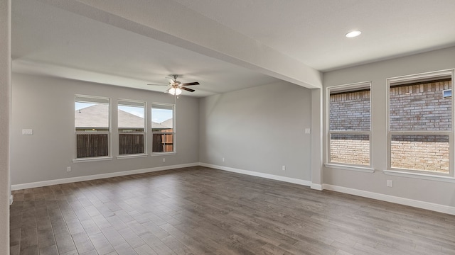 empty room with beam ceiling, hardwood / wood-style flooring, and ceiling fan