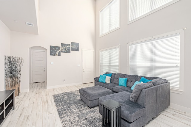 living room with a high ceiling and light wood-type flooring