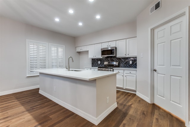 kitchen with appliances with stainless steel finishes, an island with sink, white cabinetry, and sink