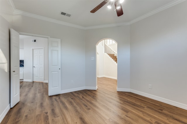 unfurnished room featuring ceiling fan, wood-type flooring, and ornamental molding