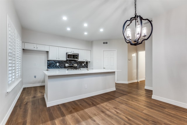 kitchen featuring white cabinets, a notable chandelier, stainless steel appliances, and an island with sink