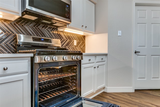 kitchen with tasteful backsplash, white cabinetry, and stainless steel appliances