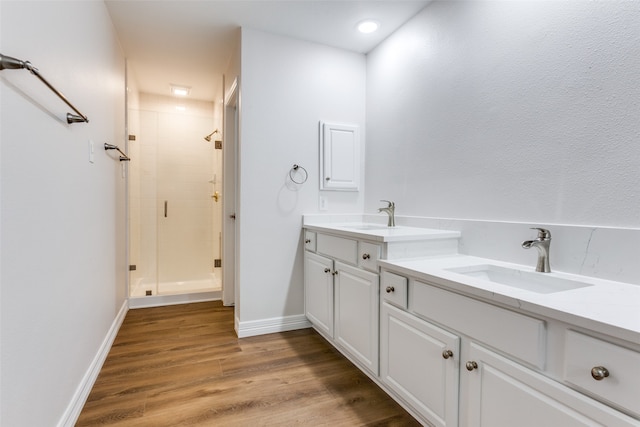 bathroom with wood-type flooring, vanity, and walk in shower