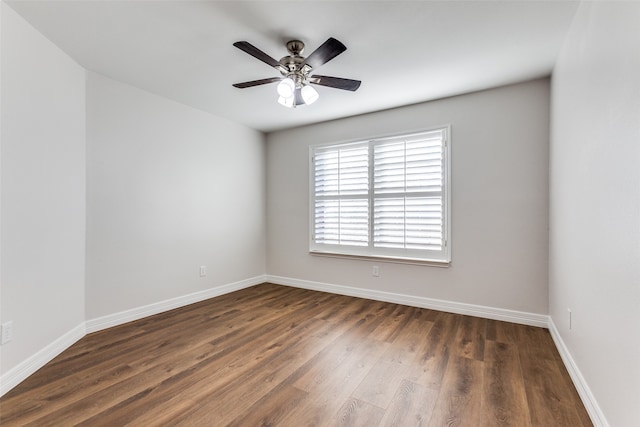 empty room with ceiling fan and dark hardwood / wood-style flooring