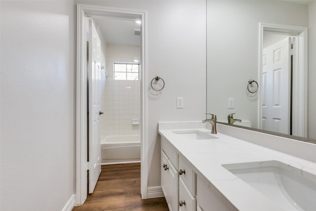 bathroom featuring hardwood / wood-style floors, vanity, and tiled shower / bath combo