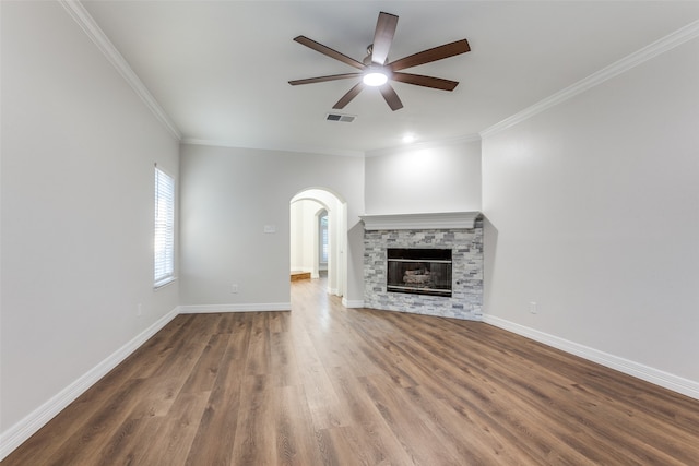 unfurnished living room featuring a fireplace, dark hardwood / wood-style floors, ceiling fan, and ornamental molding