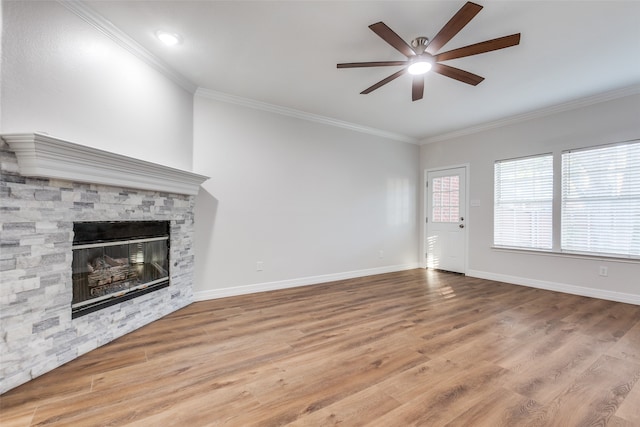 unfurnished living room featuring ceiling fan, a stone fireplace, crown molding, and light hardwood / wood-style flooring