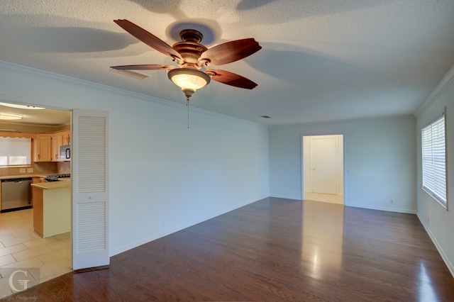 empty room featuring ceiling fan, ornamental molding, a textured ceiling, and hardwood / wood-style flooring