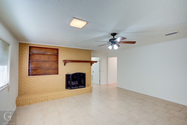 unfurnished living room with ceiling fan, a brick fireplace, a textured ceiling, and built in shelves