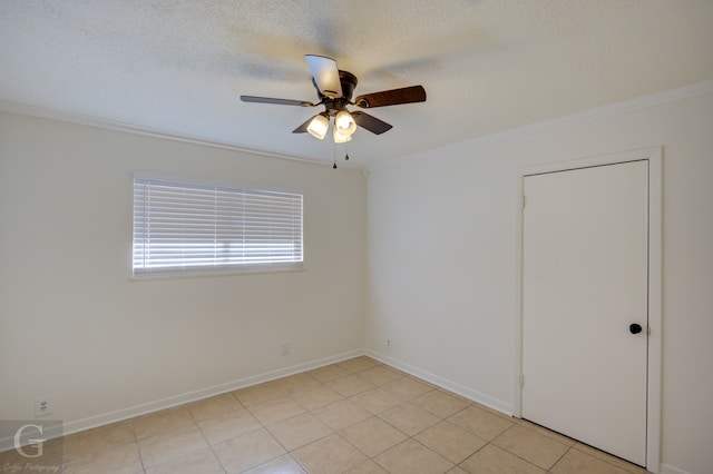 tiled empty room with ceiling fan, a textured ceiling, and ornamental molding