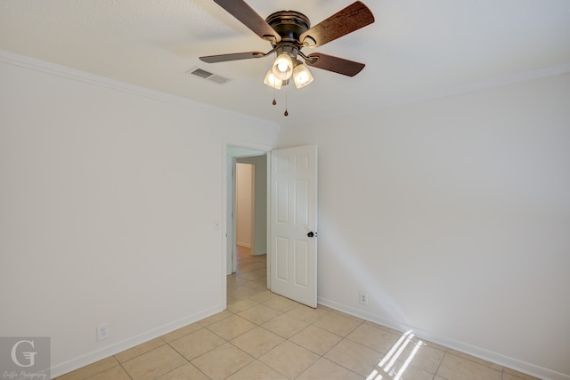 empty room featuring ceiling fan, light tile patterned floors, and crown molding