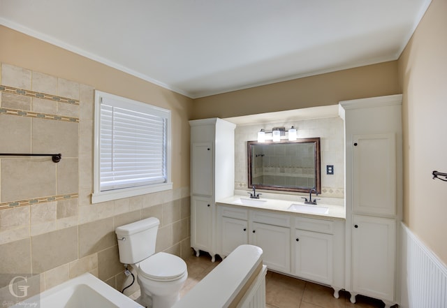 bathroom featuring vanity, a bath, tile patterned floors, toilet, and tile walls