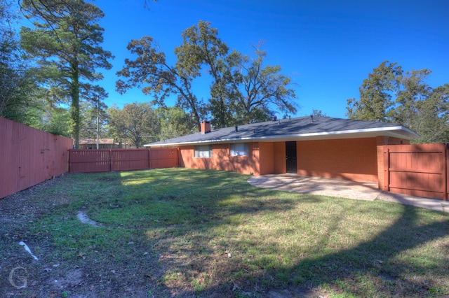 rear view of property featuring a yard and a patio