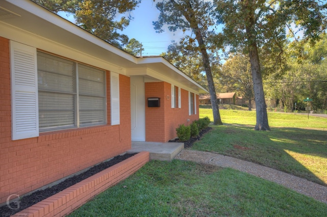 entrance to property with a lawn