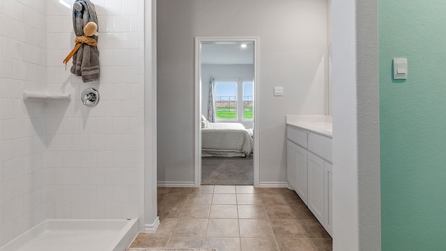 bathroom featuring tile patterned floors, vanity, and tiled shower