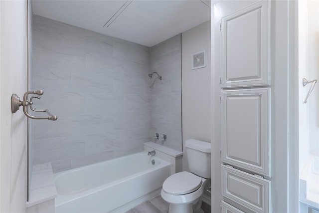 bathroom featuring tiled shower / bath, wood-type flooring, and toilet