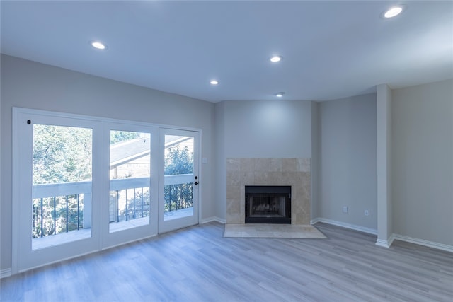 unfurnished living room with a tile fireplace and hardwood / wood-style flooring