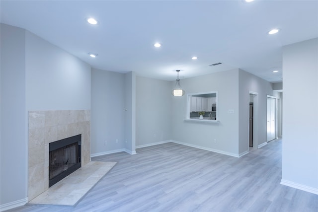 unfurnished living room with a fireplace and light hardwood / wood-style flooring