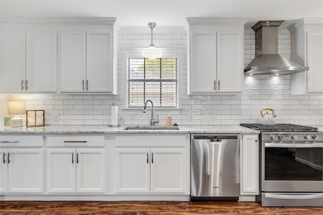 kitchen featuring white cabinetry, sink, wall chimney range hood, and appliances with stainless steel finishes