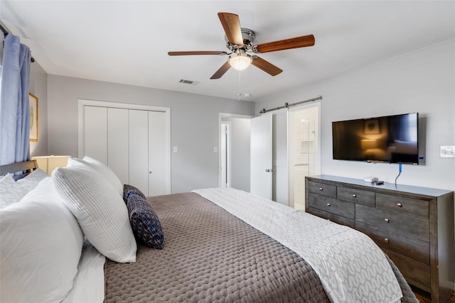 bedroom featuring ceiling fan and a barn door