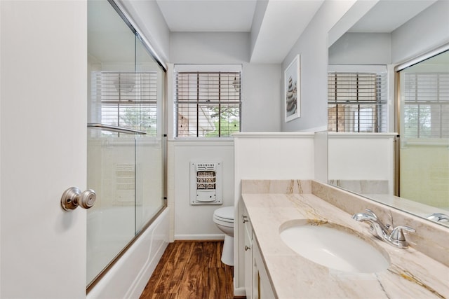 full bathroom with bath / shower combo with glass door, vanity, wood-type flooring, and toilet