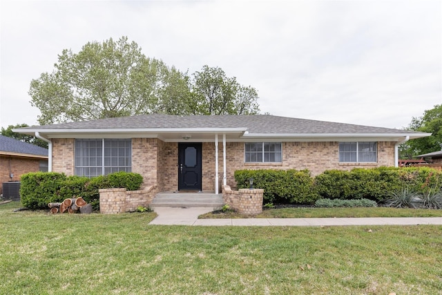 single story home featuring cooling unit and a front yard