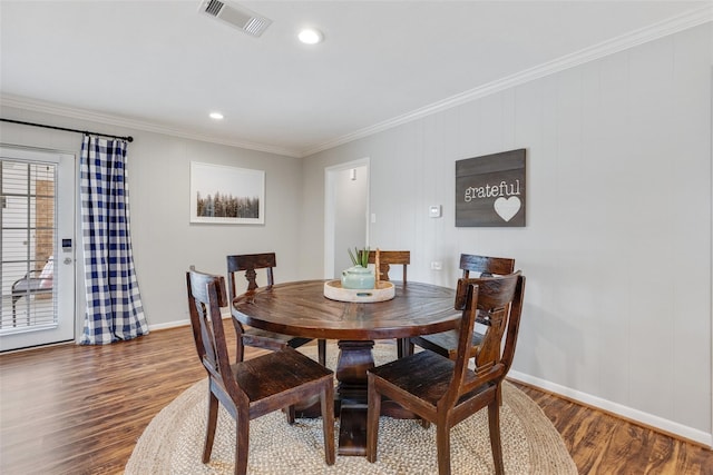 dining area featuring wood-type flooring and ornamental molding